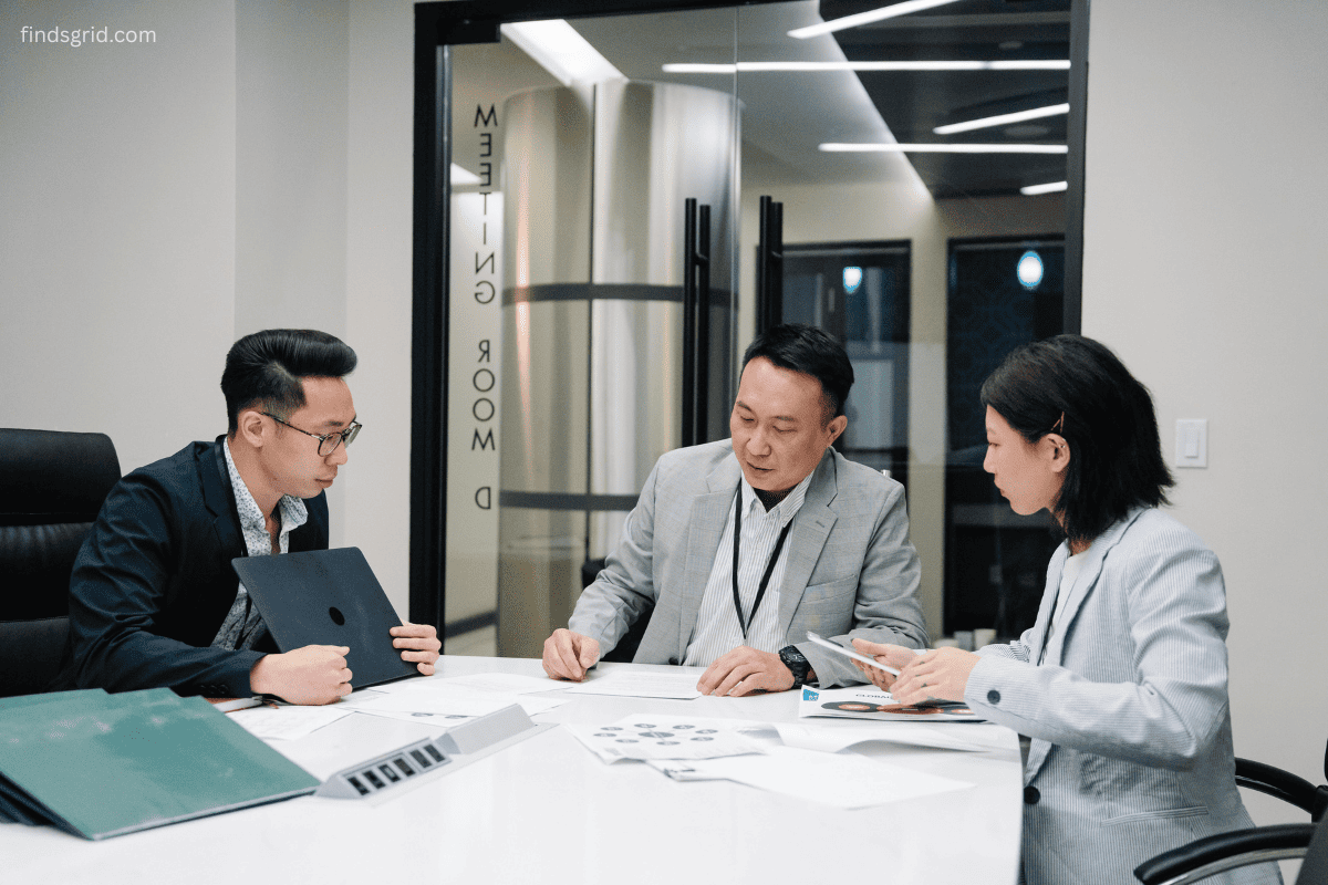 Business professionals discussing notes during an office meeting