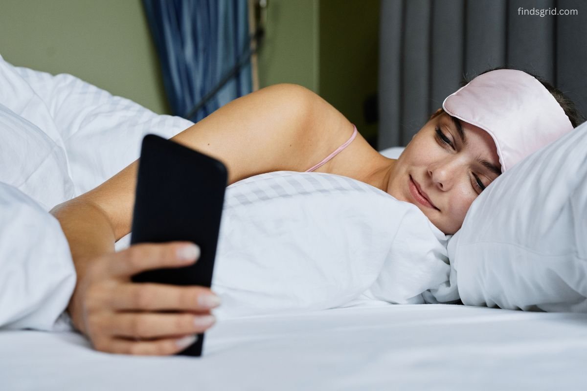 Person lying in bed looking at phone, showing how neck pain from phone in bed starts