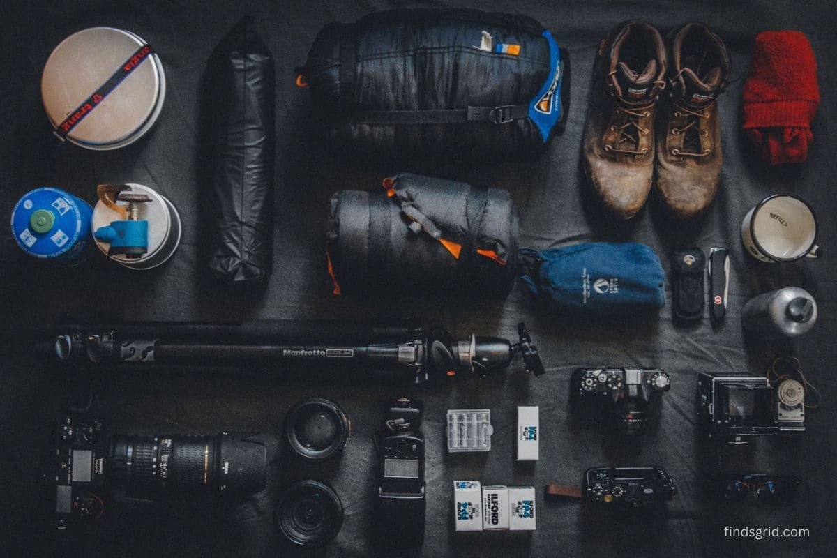 Camping and hiking gear spread out on the floor to sort before off-season storage