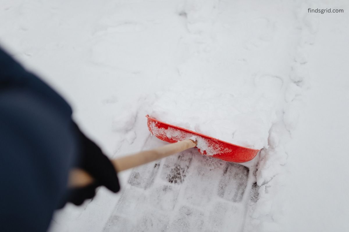 cold weather road trip emergency kit with shovel in a car trunk