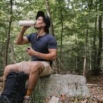 Hiker learning how to filter creek water safely at a mountain stream