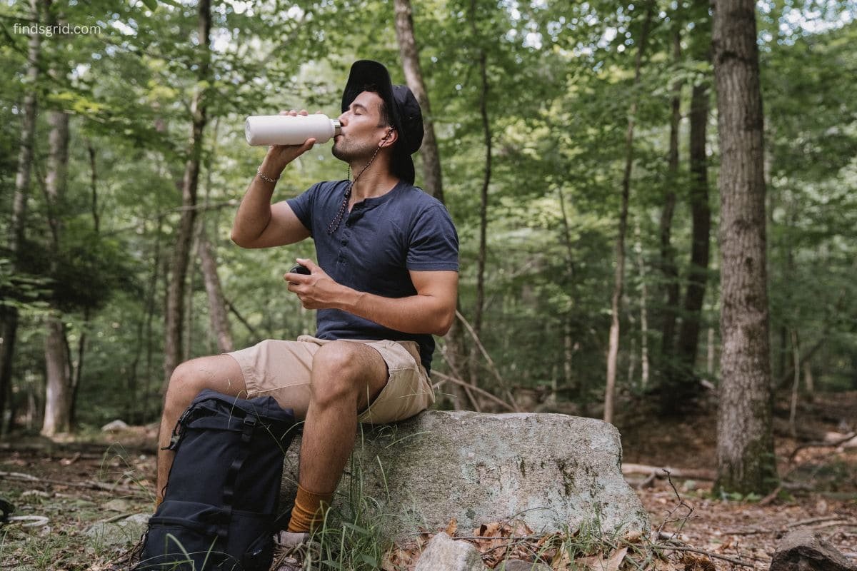Hiker learning how to filter creek water safely at a mountain stream