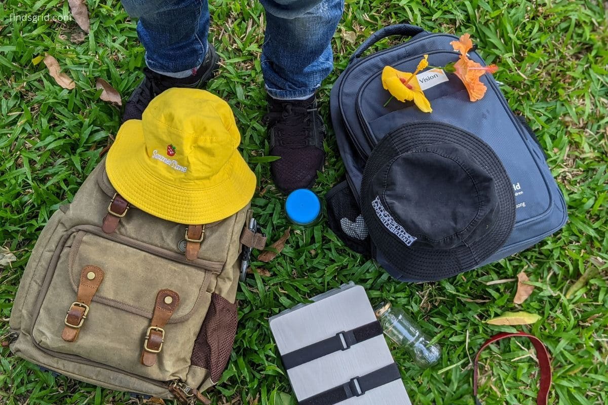 Backpack, phone and lens cloth laid out for outdoor mobile camera field prep