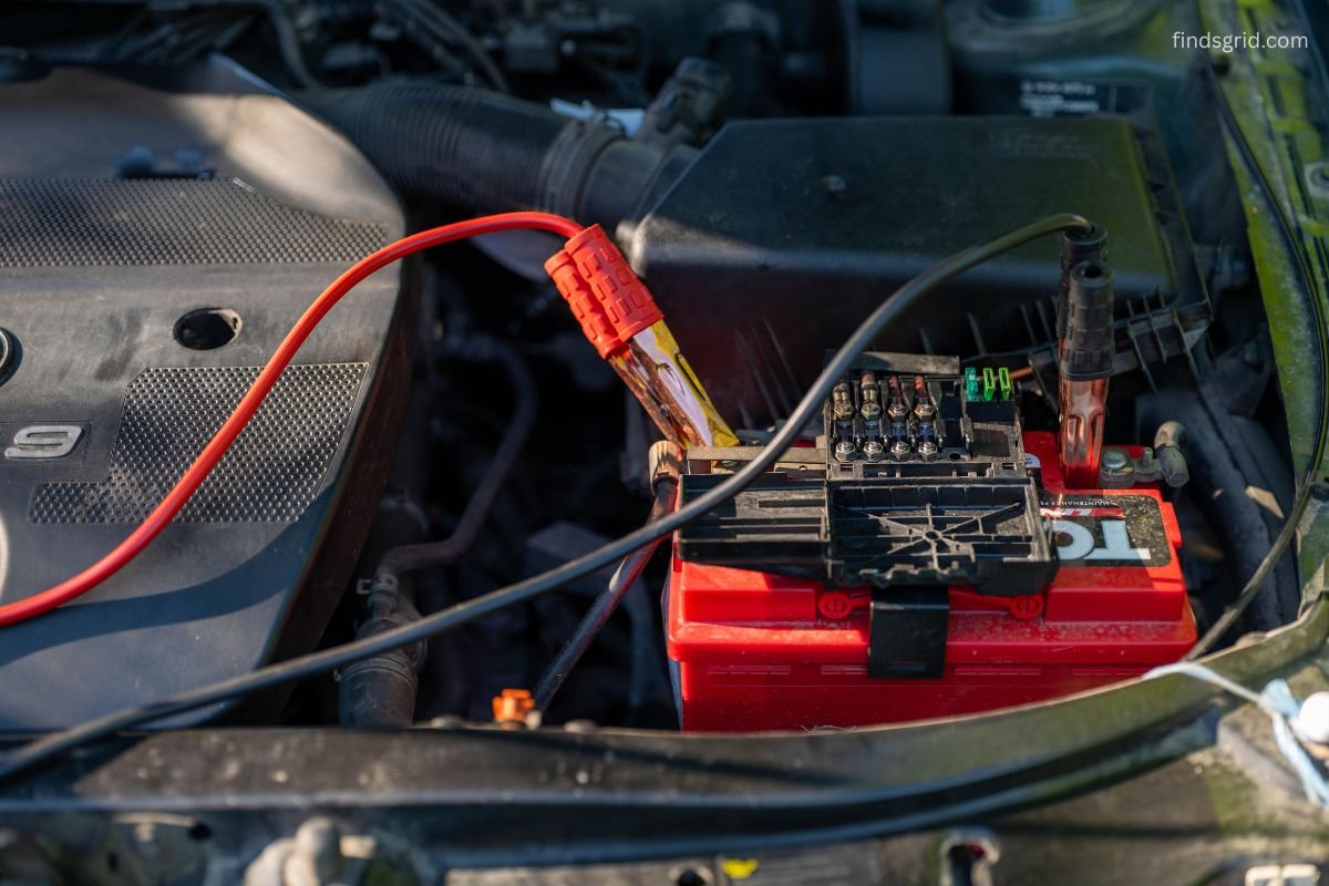 portable jump starter connected to a car battery in cold weather